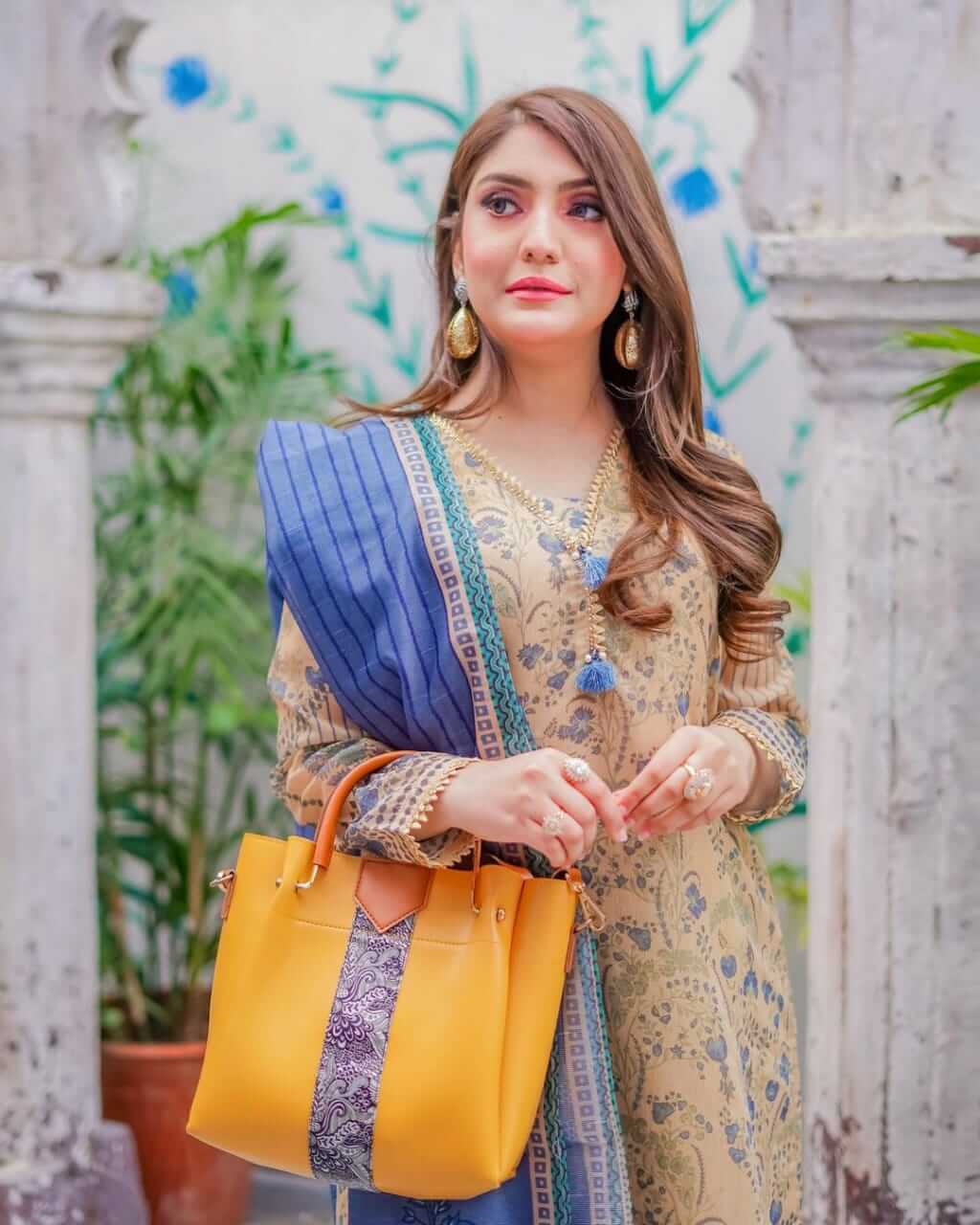 Model standing with top handle cross body hand bag